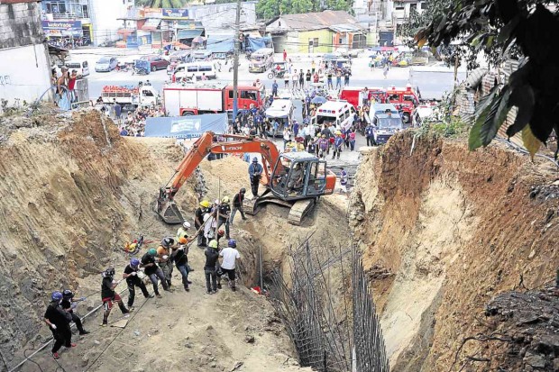 ENTOMBED Rescuers descend on the Antipolo City construction site where a landslide killed three of the five workers who were erecting steel bars for a residential building project Thursday morning.  NIÑO JESUS ORBETA