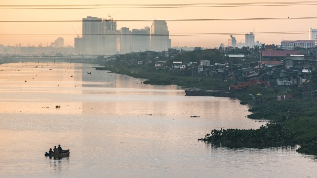 HUMAN INTEREST / SEPTEMBER 18, 2015 Children paddles around Pasig River during sunset as the Building and slums of Makati reflects to the water. INQUIRER PHOTO / JILSON SECKLER TIU