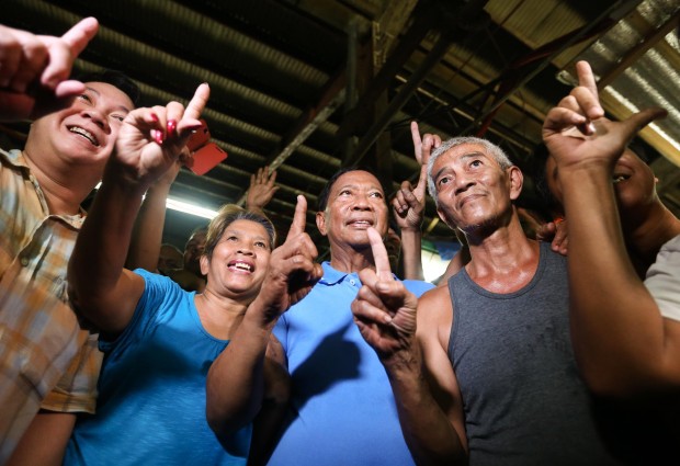 United Nationalist Alliance presidential candidate Vice President Jejomar Binay with some vendors and buyers showing the "one" or "una" hand sign during a campaign sortie in Kamuning Public Market,  Quezon City. INQUIRER PHOTO/LYN RILLON