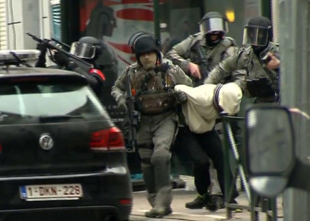 ADDING IDENTITY OF MAN IS CONFIRMED TO BE SALAH ABDESALAM - In this framegrab taken from VTM, armed police officers escort Salah Abdeslam to a police vehicle during a raid in the Molenbeek neighborhood of Brussels, Belgium, Friday March 18, 2016. The identity of Salah Abdeslam is confirmed Saturday March 19, 2016, by French police and deputy mayor of Molenbeek, Ahmed El Khannouss quoting official Belgium police sources. After an intense four-month manhunt across Europe and beyond, police on Friday captured Salah Abdeslam, the top suspect in last year's deadly Paris attacks, in the same Brussels neighborhood where he grew up.  (VTM via AP) BELGIUM OUT