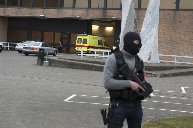 A special forces police officer guards as a police convoy and ambulance thought to be carrying captured fugitive Salah Abdeslam arrives at the federal penitentiary in Bruges, Belgium, on Saturday, March 19, 2016. Salah Abdeslam, the top suspect in last year's Paris attacks, was charged with terrorist murder on Saturday by Belgian authorities and his lawyer vowed to fight any attempt to extradite him to France to stand trial for the slaughter of 130 people. (AP Photo/Geoffroy Van der Hasselt)
