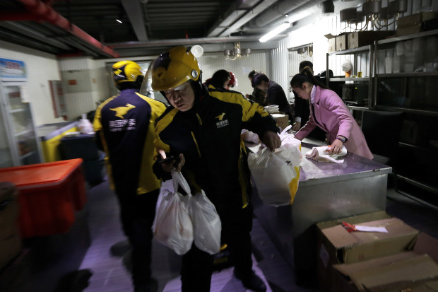 In this March 1, 2016 photo, food delivery workers from Meituan, an E-commerce company, prepare to deliver orders placed online from a center in Beijing. As China's top leaders gather for its annual legislature this week, delegates will focus on the ruling party’s new development plan - the latest chapter in a marathon effort to transform China into a middle-income economy with self-sustaining growth driven by consumer spending instead of investment, trade and heavy industry. Retailing, e-commerce and other services businesses are growing and absorbing some idled workers, but many are still struggling to find work. (AP Photo/Andy Wong)