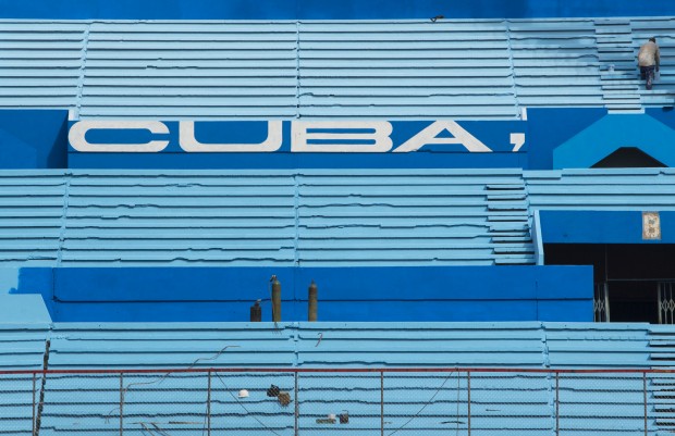 A worker paints the stands at the Latinoamericano Stadium baseball arena in Havana, Cuba, Friday, March 4, 2016. U.S. President Barack Obama plans to attend the Tampa Bay Rays' exhibition game at the arena on March 22 during his visit to Cuba. (AP Photo/Desmond Boylan)