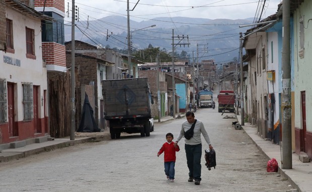 In this Nov. 6, 2015 photo, narcotics police Sgt. Johnny Vega walks with his son Juan in Talavera, Peru. On the morning of Aug. 20, 2014, an assassin tried to kill Vega. By the time he reached the emergency room, Vega had lost so much blood he nearly passed out. Eighteen months later, he is struggling to mend. (AP Photo/Martin Mejia)