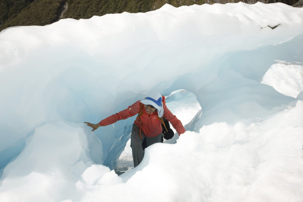 In this Feb. 6, 2016 photo, tourists who have taken a helicopter trip onto the Fox Glacier climb through a hole in the ice in New Zealand. The Fox and Franz Josef glaciers have been melting at such a rapid rate that it has become too dangerous for tourists to hike onto them from the valley floor, ending a tradition that dates back a century. (AP Photo/Nick Perry)
