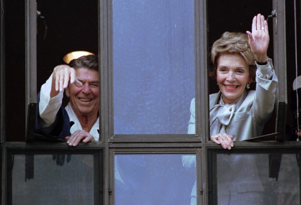 FILE - In this July 18, 1985, file photo, President Ronald Reagan and his wife, Nancy, wave from windows of his hospital room at the Navy Medical Center in Bethesda, Md. The former first lady has died at 94, The Associated Press confirmed Sunday, March 6, 2016. (AP Photo/Scott Stewart, File)