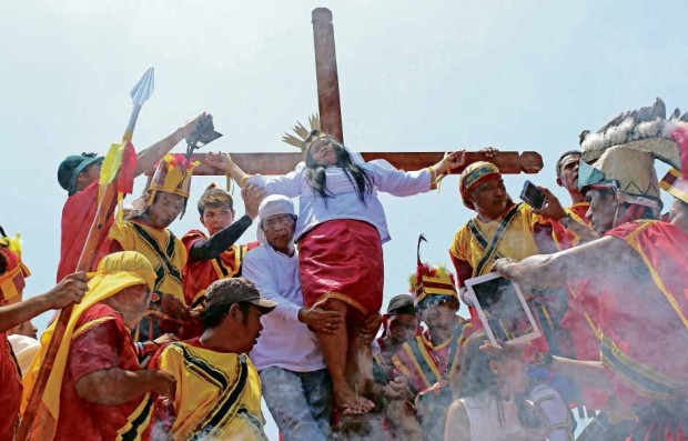 LENTEN RITUAL Precy Valencia is nailed to the cross during a reenactment of the crucifixion of Jesus Christ on Good Friday in Barangay Kapitangan in Paombong, Bulacan province. KIMBERLY DELA CRUZ