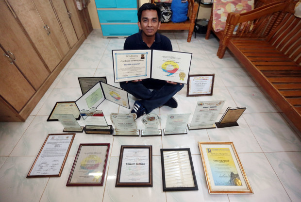 MR. HONESTY Airport janitor Ronald Gadayan shows the awards given to him for honesty by various groups at his house in Norzagaray, Bulacan province. GRIG C. MONTEGRANDE