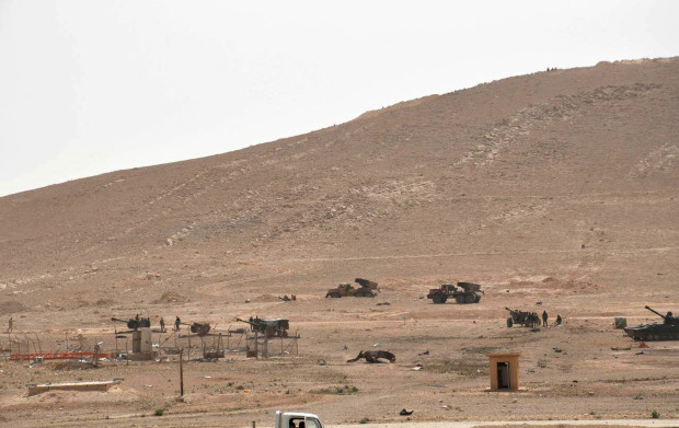 In this photo released on Thursday,  March 24, 2016, by the Syrian official news agency SANA, Syrian government forces deploy at the entrance of Palmyra, central Syria. Syrian government forces recaptured a Mamluk-era citadel in Palmyra from the extremist Islamic State group on Friday, Syrian state media and monitoring groups said, as the fierce battle for control of the historic town entered its third day. (SANA via AP)
