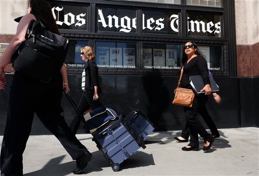 In this Monday, Oct. 5, 2015, file photo, pedestrians walk past the Los Angeles Times building in downtown Los Angeles. Tribune Publishing announced Thursday, Feb. 4, 2016, that the company is getting a $44.4 million cash boost from investor Michael W. Ferro Jr., chairman and CEO of Chicagos Merrick Media, who will become the nonexecutive chairman of the company that owns the Chicago Tribune and the Los Angeles Times. (AP Photo/Richard Vogel, File)