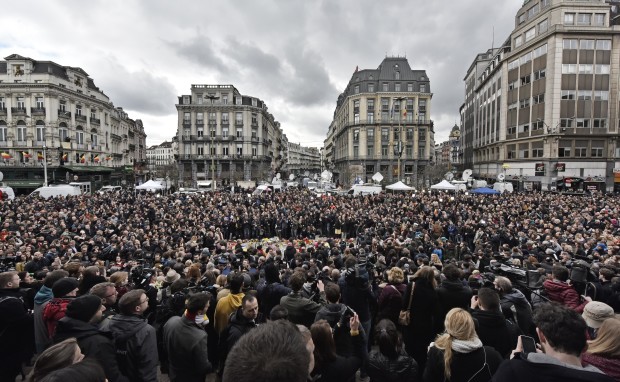 People observe a minute of silence at the Place de la Bourse in the center of Brussels, Wednesday, March 23, 2016. Bombs exploded yesterday at the Brussels airport and one of the city's metro stations Tuesday, killing and wounding scores of people, as a European capital was again locked down amid heightened security threats. (AP Photo/Martin Meissner)