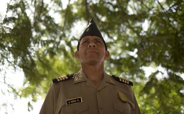 In this March 30, 2015 photo, narcotics police Sgt. Johnny Vega, poses for a portrait in Lima, Peru. In a country where cops are as likely to take bribes as to make arrests, Vega was an anomaly. Three times, he was named his province's police officer of the year. On Aug. 20, 2014 he was shot in what authorities called payback for taking down a drug clan. (AP Photo/Rodrigo Abd)