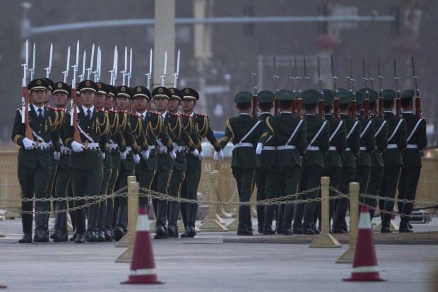 Chinese paramilitary policemen march during a flag raising on Tiananmen Square  outside the Great Hall of the People where the annual National People's Congress will open in Beijing, Saturday, March 5, 2016. (AP Photo/Ng Han Guan)
