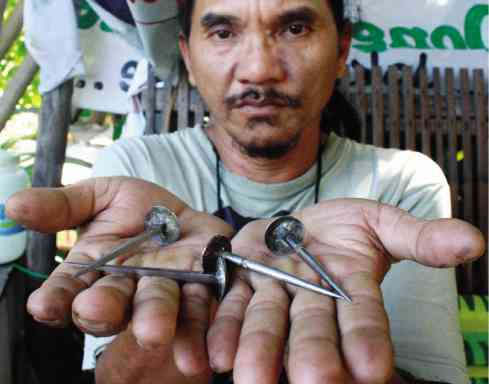 RUBEN Enaje shows off nails which are pounded into his hands and feet every Good Friday.      E.I. REYMOND T. OREJAS/CONTRIBUTOR