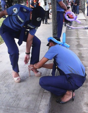 BEST FOOT FORWARD A police trainee helps a colleague put on high heels during the third staging of “In Her Shoes.” KIMBERLIE QUITASOL/INQUIRER NORTHERN LUZON