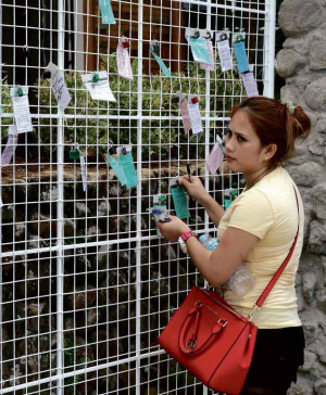 LOCKED PRAYERS A devotee inspects her padlock at the “prayer lock” station, the latest spiritual attraction at Kamay ni Hesus Shrine in Lucban, Quezon. Up to 6million pilgrims are expected to visit the place during Holy Week. DELFIN T. MALLARI JR./INQUIRER SOUTHERN LUZON