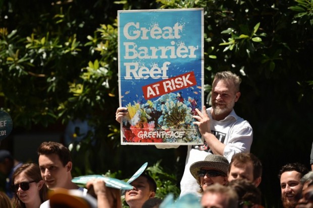 In this file photo, protesters hold banners outside the headquarters of the Commonwealth Bank in Sydney to call for the conservation of the Great Barrier Reef. AFP PHOTO/Peter PARKS / AFP / PETER PARKS