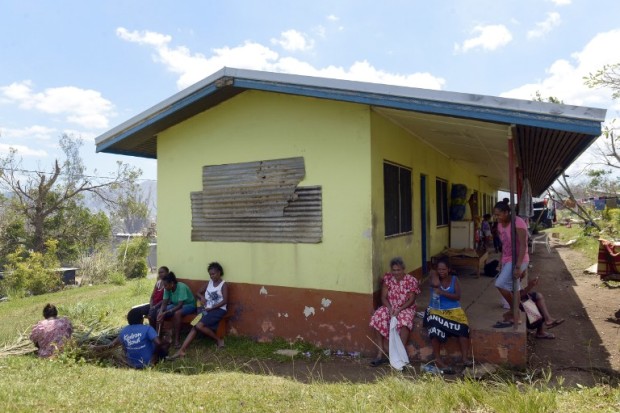 People take shelter at the Apostolic Church of Tagabe, a district of Port Vila, on March 20, 2015, after Cyclone Pam devastated Vanuatu, as concerns mount about supplies of fresh water across the ravaged Pacific nation.  In a situation report, the United Nation (UN) raised the number of deaths from 13, and said priority needs across the sprawling archipelago, where crops have been destroyed and houses razed, were for potable water, food, shelter and health.   AFP PHOTO / FRED PAYET / AFP / FRED PAYET