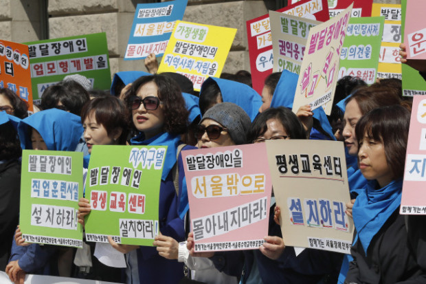 Members of civic group Korean Parents’ Network for People with Disabilities urge the city government to draw up support measures for children with developmental disabilities at Seoul City Hall, Monday. THE KOREA HERALD/ASIA NEWS NETWORK