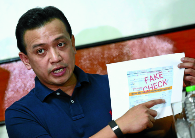 Vice presidential candidate Sen. Antonio Trillanes IV with a print-out copy of a fake cheque in his name made by supporters of presidential candidate Davao City Mayor Rodrigo Duterte during a press briefing held at the Magdalo headquarters in Quezon City. INQUIRER PHOTO/LYN RILLON