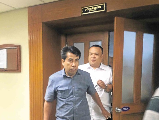 NOT TODAY  Ryan Joseph Jaworski (in white), who is facing charges for attempted murder and illegal possession of firearms, hurriedly leaves the court after his arraignment is moved to June 9. MARICAR BRIZUELA 