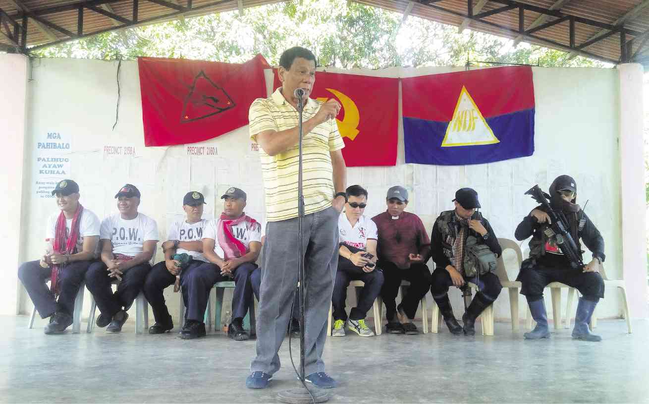 DUTERTE CONNECTION  Five police officers captured by the New People’s Army are turned over to presidential candidate and Davao City Mayor Rodrigo Duterte during ceremonies in a rebel-influenced village in the city’s Paquibato District. Seated at right are two NPA members. (Related story in Across the Nation, Page A18.) BARRY OHAYLAN/CONTRIBUTOR