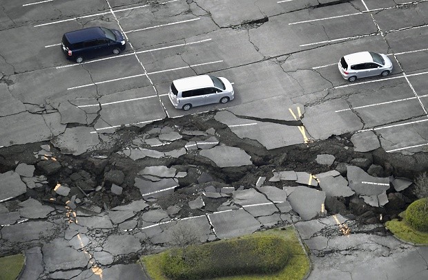 Vehicles sit at a parking lot damaged by an earthquake at Minamiaso in Kumamoto prefecture, southern Japan Saturday, April 16, 2016. A powerful earthquake struck southern Japan early Saturday, barely 24 hours after a smaller quake hit the same region. Muneyuki Tomari/Kyodo News via AP