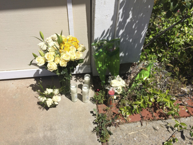A makeshift memorial of roses and prayer candles is seen outside home of Shamima and Golam Rabbi, a couple found shot to death in San Jose, Calif., Thursday, April 28, 2016. Two California brothers were arrested Thursday in connection with the shooting deaths of their parents, who were popular fixtures at their mosque for three decades and had helped relatives emigrate from their native Bangladesh. The couple was found slain Sunday in their home. (AP Photo/Paul Elias)