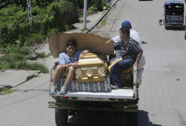 People carry an empty coffin on a pick up truck as they drive to collect the body of an earthquake victim in Pedernales, Ecuador, Sunday, April 17, 2016. Rescuers pulled survivors from the rubble Sunday after the strongest earthquake to hit Ecuador in decades flattened buildings and buckled highways along its Pacific coast on Saturday. The magnitude-7.8 quake killed hundreds of people. (AP Photo/Dolores Ochoa)
