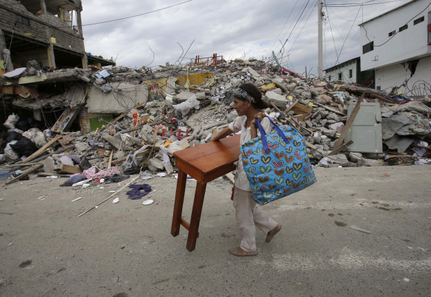 A woman carries a table through the street after an earthquake in Pedernales, Ecuador, Sunday, April 17, 2016. Rescuers pulled survivors from the rubble Sunday after the strongest earthquake to hit Ecuador in decades flattened buildings and buckled highways along its Pacific coast on Saturday. The magnitude-7.8 quake killed hundreds of people. (AP Photo/Dolores Ochoa)