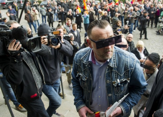 Lutz Bachmann, founder of Germany's xenophobic and anti-Islamic PEGIDA movement (Patriotic Europeans Against the Islamisation of the Occident) has his eyes covered as if pixelized by media as he arrives for his trial on April 19, 2016 in Dresden, eastern Germany. Bachmann has to appear in court on hate speech charges for branding refugees "cattle" and "scum" on social media. He was charged in October 2015 with inciting racial hatred through a series of widely-shared Facebook posts. / AFP PHOTO / Robert MICHAEL
