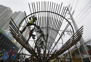 In this Wednesday, Aug. 12, 2015 photo, Filipino workers arrange metal rods at a government road project in suburban Quezon City, north of Manila, Philippines. Manila and other cities are choked with construction sites for office and apartment towers. But spending on roads, railways and other unglamorous but essential infrastructure collapsed after the 1997 financial crisis and has yet to recover. (AP Photo/Aaron Favila)