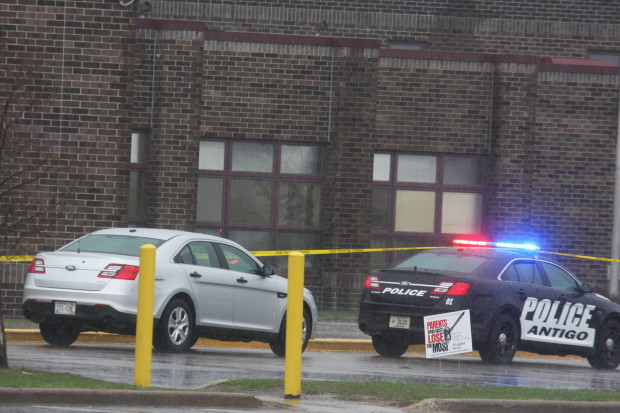 Two Antigo police department vehicles sit in front of the entrance to Antigo High School, Sunday, April 24, 2016, where an 18-year-old gunman opened fire late Saturday outside of a prom at the school. The shooter wounded two students before a police officer who was in the parking lot fatally shot him, authorities said Sunday. (Fred Berner/Antigo Daily Journal via AP) MANDATORY CREDIT