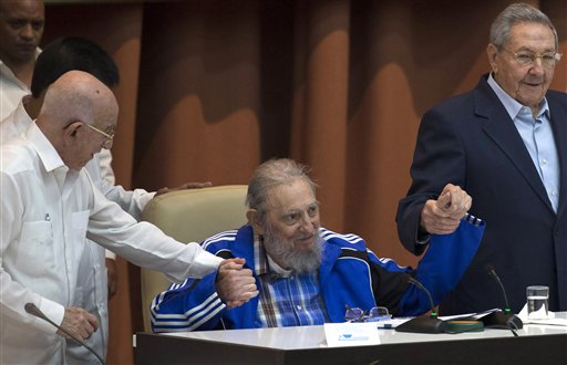 Fidel Castro sits as he clasps hands with his brother, Cuban President Raul Castro, right, and second secretary of the Central Committee, Jose Ramon Machado Ventura, moments before the playing of the Communist party hymn during the closing ceremonies of the 7th Congress of the Cuban Communist Party, in Havana, Cuba, Tuesday, April 19, 2016. Fidel Castro formally stepped down in 2008 after suffering gastrointestinal ailments and public appearances have been increasingly unusual in recent years. (Ismael Francisco/Cubadebate via AP)