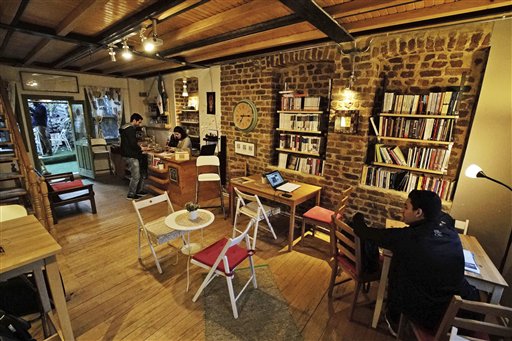 In this photo taken on Friday, April 1, 2016, customers are seen Pages, a rustic three story-Arabic language bookshop in Istanbul, Turkey. The bookstore has become an anchor for many Syrians who have stayed put in Turkey but crave a taste of home. The founder and owner of Pages, Samer al-Kadri, a refugee himself, says the store strives to be a bridge between Syrians, Turks and the myriad of foreigners who visit the city. Its weekly program includes oriental music concerts and, starting soon, language exchanges in Arabic, English and Turkish. Books are available in all three languages. (AP Photo/Bram Janssen)