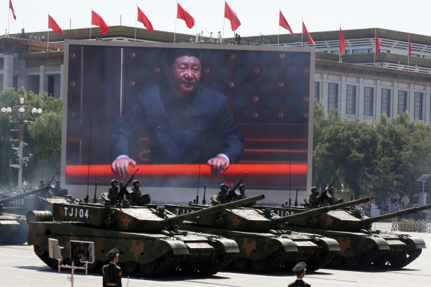 FILE - In this Thursday, Sept. 3, 2015 file photo, Chinese President Xi Jinping is displayed on a screen as Type 99A2 Chinese battle tanks take part in a parade commemorating the 70th anniversary of Japan's surrender during World War II held in front of Tiananmen Gate in Beijing. Chinese President Xi Jinping is assuming a more direct role as commander of the country's powerful armed forces with the new title of commander in chief of its Joint Operations Command Center, as revealed in news reports run on Wednesday, April 20, and Thursday, April 21, 2016, in which he appeared publicly for the first time in camouflage battle dress wearing the center's insignia.(AP Photo/Ng Han Guan, File)