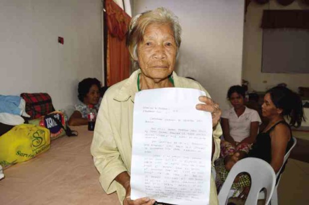 DETAINEE Valentina Berlin, 78, of Barangay Maria Caridad in Arakan, North Cotabato province, holds up her sworn statement at the Kidapawan City Convention Center, where she and 40 others are being detained for their alleged participation in a rally of drought-stricken farmers on April 1. WILLIAMOR A. MAGBANUA/INQUIRER MINDANAO