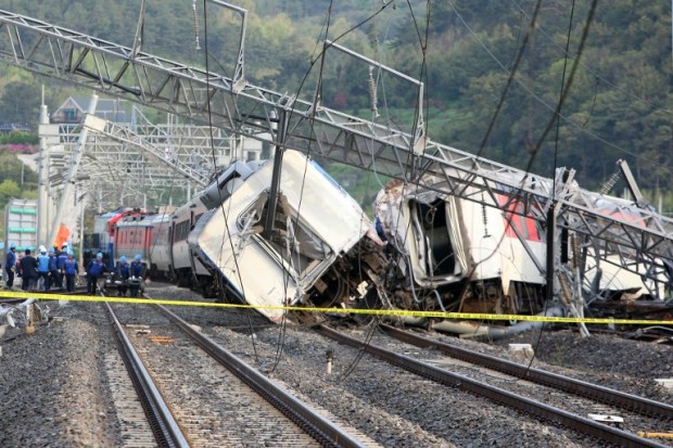 South Korea railway workers struggle to put a derailed passenger train back on track in the southern port city of Yeosu on April 22, 2016. The train derailed early on April 22, leaving the locomotive driver dead and eight passengers injured.   AFP PHOTO / YONHAP 