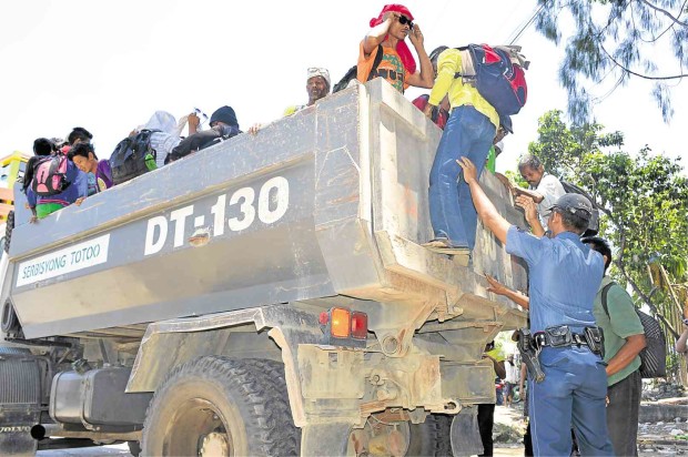 FARMERS climb aboard a dump truck that brought them home to Magpet town, North Cotabato province, after the bloody dispersal of a rally in Kidapawan City. Two protesters were killed and at least 100 others, including policemen, were wounded. Williamor A. Magbanua/Inquirer Mindanao