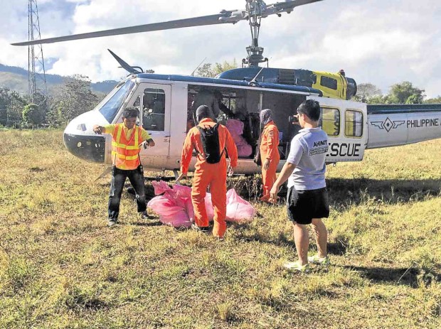 VOLUNTEERS load sacks of crushed ice onto a military helicopter that is helping fight the raging fire on  Mt. Apo, the country’s tallest peak.          ORLANDO DINOY/INQUIRER MINDANAO
