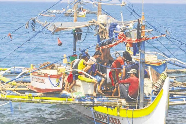 FISHERMEN from the village of Cato in Infanta town, Pangasinan province, rest after a fishing trip in the West Philippine Sea. WILLIE LOMIBAO/Inquirer Northern Luzon