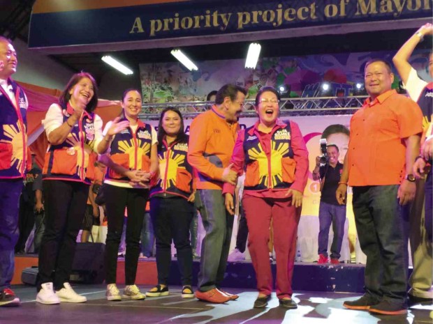  FAMILY AFFAIR Manila Mayor Joseph Estrada takes reelectionist Mayor Guia Gomez by the arm as they share a big laugh onstage, while their son Sen. JV Ejercito appears to check the crowd’s reaction during her proclamation rally Saturday night.     Jovic Yee 