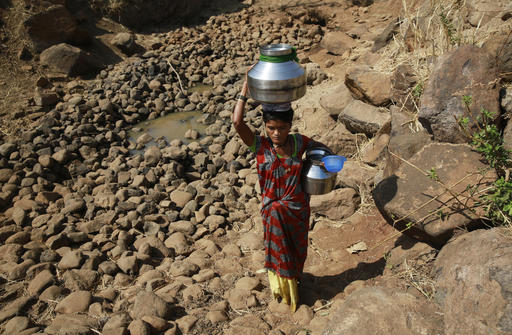 In this April 12, 2016 photo, a woman carries water from a spring at Raichi Wadi village, 120 kilometers (75 miles) north-east of Mumbai, India. Decades of groundwater abuse, populist water policies and poor monsoons have turned vast swaths of central and western India into a dust bowl, driving distressed farmers to suicide or menial day labor in the cities. AP 