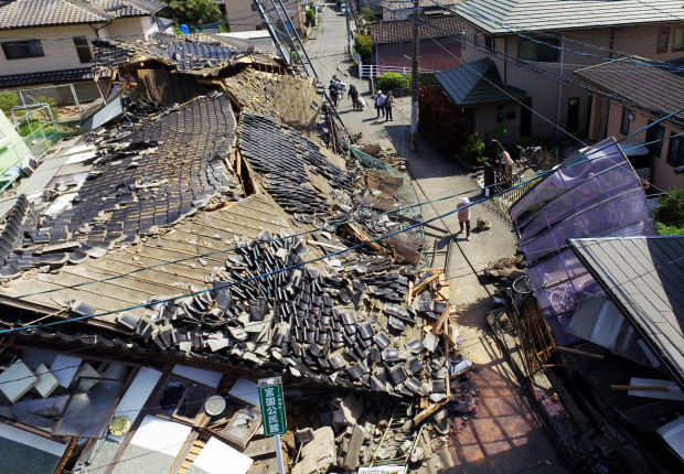 This aerial view shows damaged houses in Mashiki town, Kumamoto prefecture, southern Japan,  Friday, April 15, 2016, a day after a magnitude-6.5 earthquake. More than 100 aftershocks from Thursday night's magnitude-6.5 earthquake continued to rattle the region as businesses and residents got a fuller look at the widespread damage from the unusually strong quake, which also injured about 800 people. (Koji Harada/Kyodo News via AP) JAPAN OUT, MANDATORY CREDIT