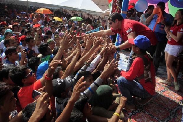 This photo taken on April 28, 2016 shows Shariff Aguak's mayoral candidate Sajid Ampatuan greeting supporters during a rally in Shariff Aguak town, Maguindanao province, in the southern Philippine island of Mindanao. Walking off stage after a rock star-like performance and rapturous crowd reaction, Sajid Ampatuan oozes confidence that he will be elected mayor of a southern Philippine town despite facing charges of mass murder. His father, former provincial governor Andal Ampatuan, allegedly ordered his sons and their armed followers to kill 58 people in November 2009 in an attempt to stop a rival's election challenge.   / AFP PHOTO / MARK NAVALES / TO GO WITH AFP STORY PHILIPPINES-VOTE-LAW-CRIME,FOCUS BY FERDINANDH CABRERA