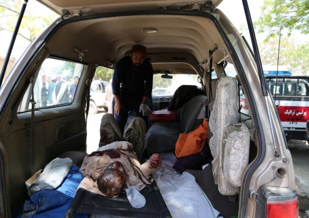An injured Afghan man lies in an ambulance in Ghazni on May 8, 2016, following an accident on the main Kabul-Kandahar Highway.    Two buses and an oil tanker collided on a major highway in eastern Afghanistan Sunday killing at least seven people, officials said, in the latest deadly road accident in the war-battered country. / AFP PHOTO / SAYED ZAKERIA