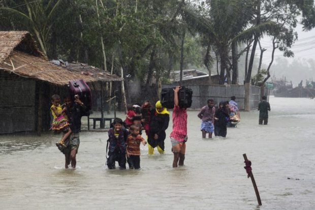 Bangladeshi villagers make their way to shelter in Cox's Bazar on May 21, 2016, as Cyclone Roanu approached.  Cyclone Roanu struck the Bangladesh coast on Saturday killing six people and forcing hundreds of thousands more to flee their homes as the storm unleashed strong winds and heavy downpours.  / AFP PHOTO / -