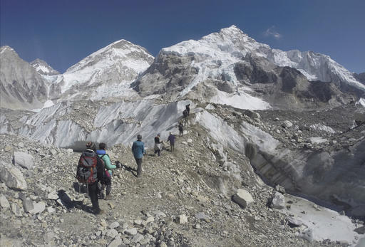 FILE - In this Monday, Feb. 22, 2016 file photo, international trekkers pass through a glacier at the Mount Everest base camp, Nepal. A Nepal official says some 30 climbers have gotten frostbite or become sick on Mount Everest, in addition to two who died in recent days on the world's highest mountain. (AP Photo/Tashi Sherpa, file)