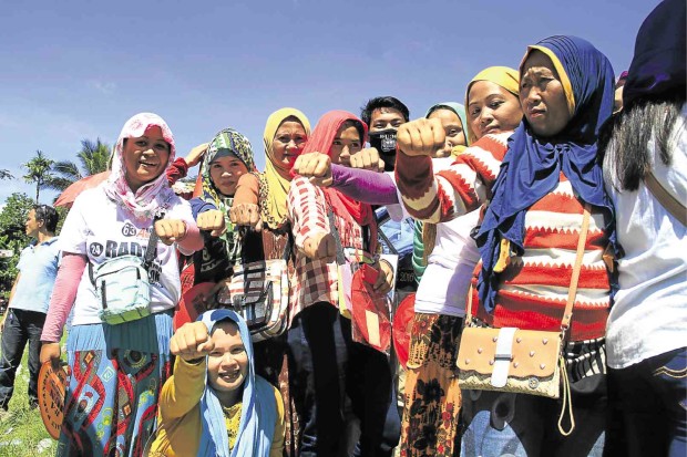 VICTORY IS OURS!  Or so these Maranao women voters seem to be saying as they punch the air with closed fists, a gesture associated with presumptive President-elect Rodrigo Duterte.  The women lined up for the special elections in Binidayan, Lanao del Sur, on Saturday. RICHEL V. UMEL/INQUIRER MINDANAO   