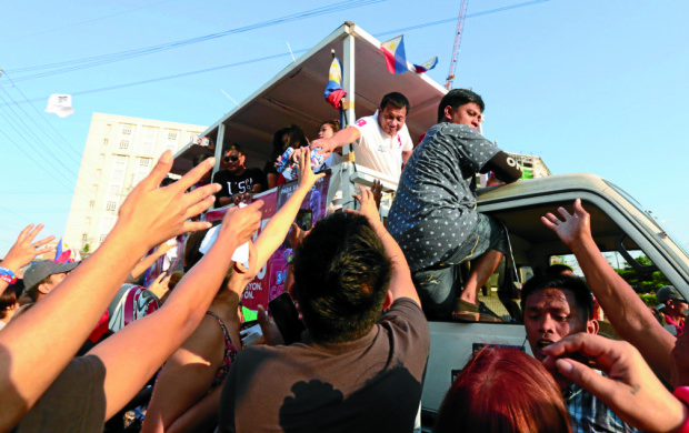 #INQBack: Then presidential candidate Rodrigo Duterte hands out t-shirt to waiting supporters during a motorcade with his running mate vice presidential candidate Sen. Alan Peter Cayetano in Pasay City on Sunday, May 1, 2016. INQUIRER FILE PHOTO/GRIG C. MONTEGRANDE